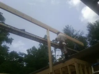Carpenter setting a ridge beam over a new addition frame — Ice Dam Removal by Roofing Brothers in Schwenksville