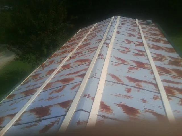 Rusted metal roof panels with new wood purlins before replacement — Storm Damage Roof Repair in Schwenksville by Roofing Brothers