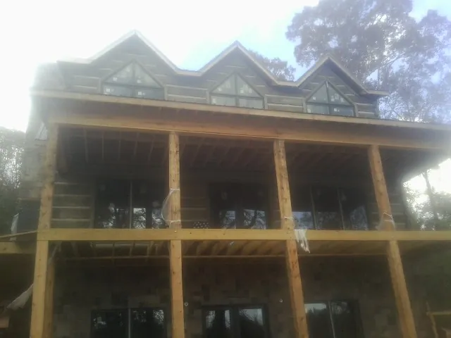 Dormers and porch framing on a large log home under construction — Roof Coating work by our crew in Schwenksville